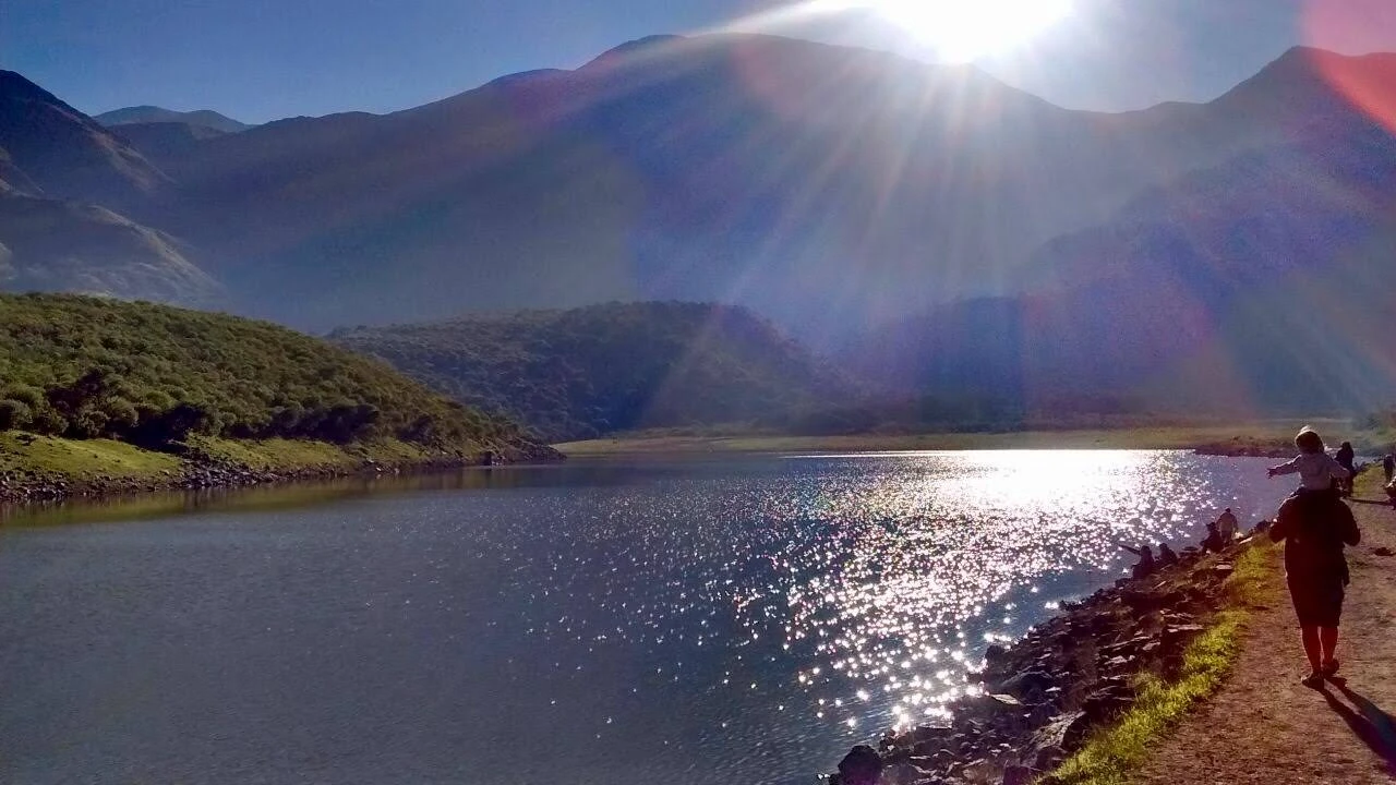 Laguna de montaña rodeada de cerros verdes en los valles de Jujuy